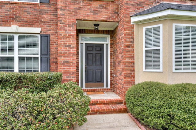 view of exterior entry featuring brick siding