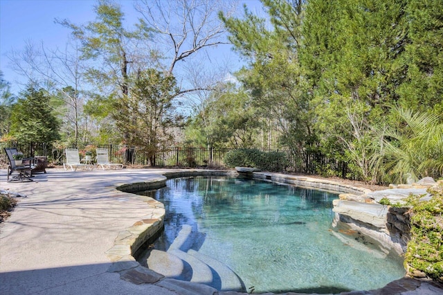 view of swimming pool featuring a patio area, fence, and a fenced in pool