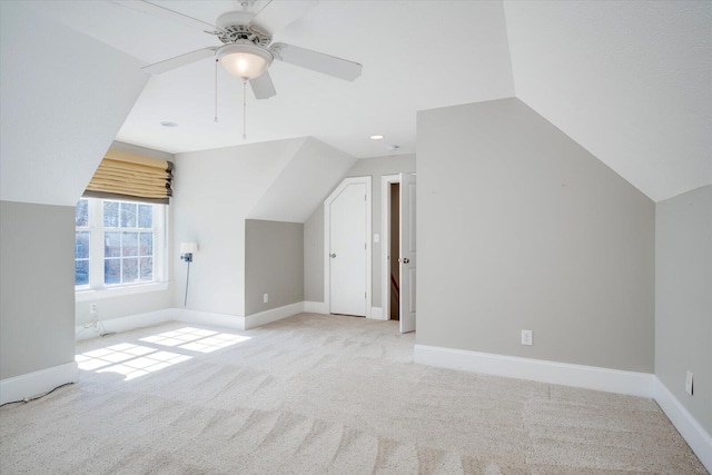 additional living space with carpet floors, vaulted ceiling, baseboards, and a ceiling fan