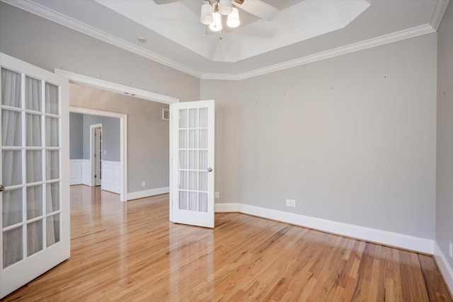 empty room featuring light wood-style flooring, crown molding, and french doors