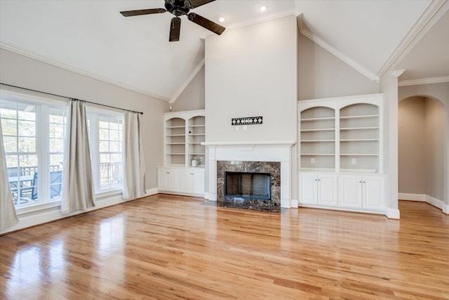 unfurnished living room featuring light wood-type flooring, ceiling fan, a premium fireplace, and baseboards