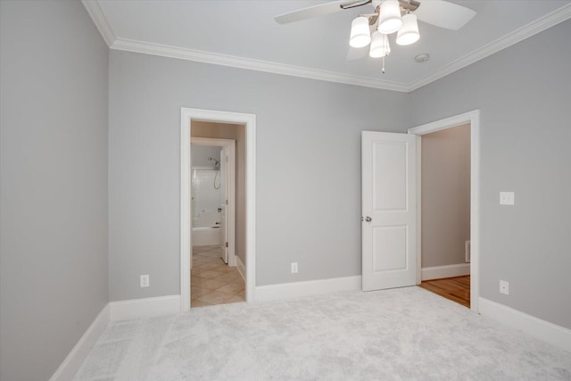 unfurnished bedroom with a ceiling fan, carpet, baseboards, and crown molding