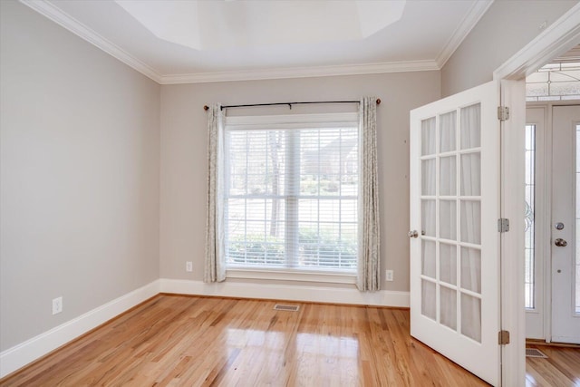 interior space with crown molding, plenty of natural light, wood finished floors, and baseboards