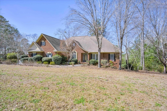 view of front of house with brick siding and a front lawn