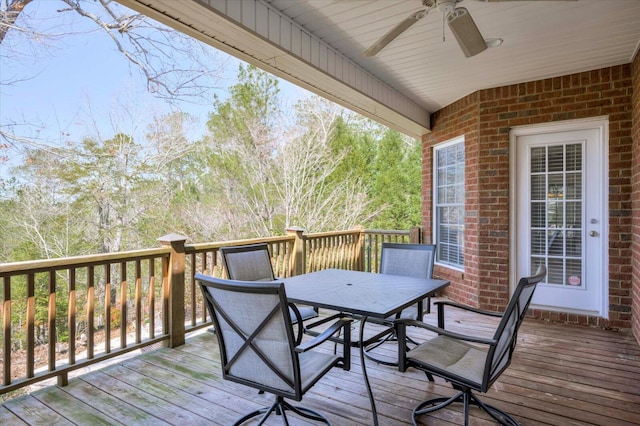 wooden terrace with outdoor dining space and a ceiling fan