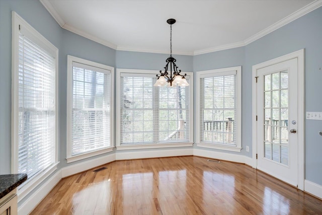 unfurnished dining area featuring visible vents, crown molding, and wood finished floors