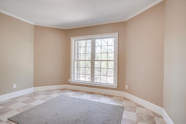 empty room with ornamental molding, a wealth of natural light, and baseboards