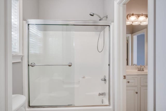 full bath with toilet, enclosed tub / shower combo, and vanity