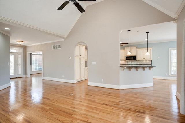 unfurnished living room featuring ornamental molding, a healthy amount of sunlight, and visible vents