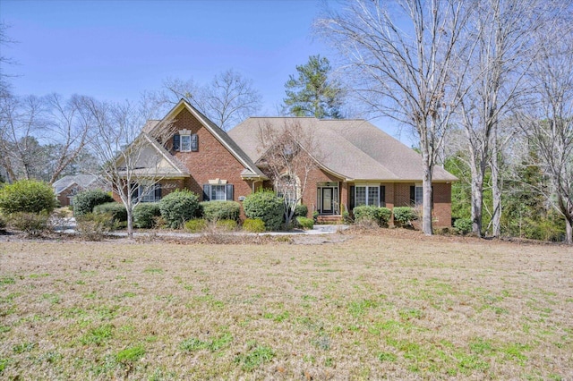 view of front of property featuring brick siding and a front yard