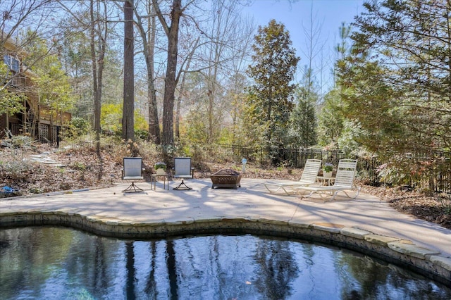 view of pool with an outdoor fire pit, a patio area, and fence