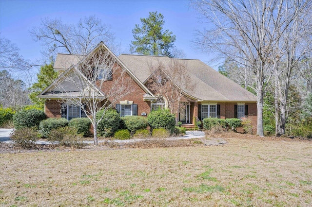 view of front of home with brick siding and a front yard