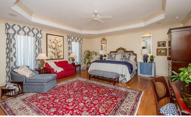 bedroom featuring a tray ceiling, ceiling fan, and hardwood / wood-style flooring