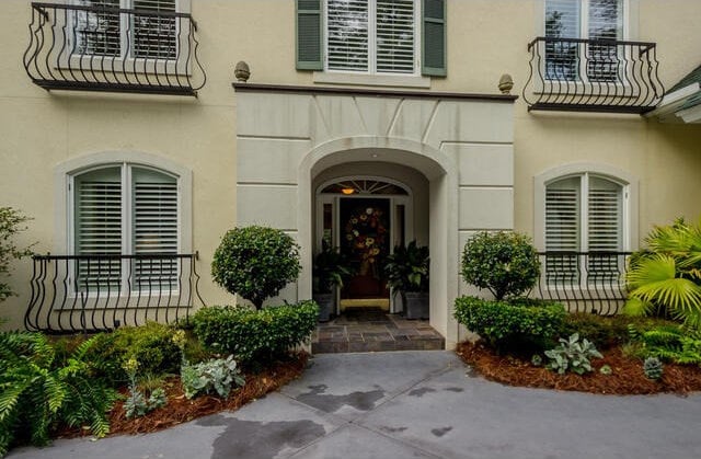 view of exterior entry with a balcony