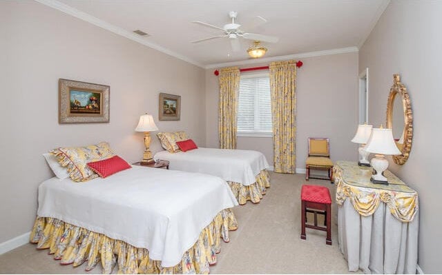 carpeted bedroom featuring ceiling fan and crown molding