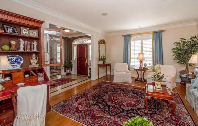 living area with hardwood / wood-style floors and crown molding