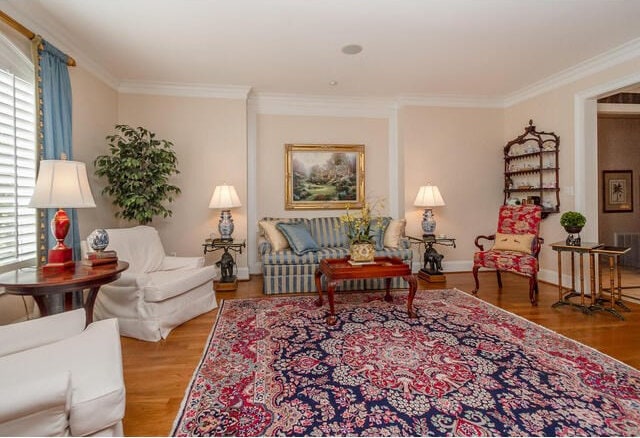 living area with hardwood / wood-style flooring and crown molding