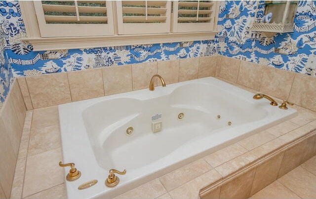 bathroom with tile patterned flooring and tiled tub