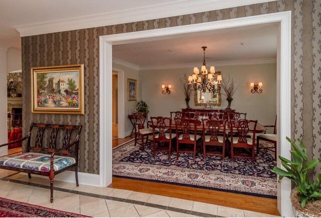 tiled dining room with a large fireplace, crown molding, and an inviting chandelier