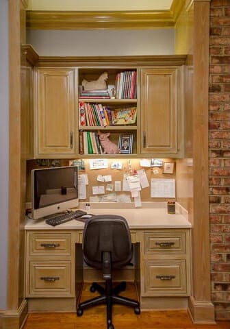 office space with ornamental molding, built in desk, and light wood-type flooring