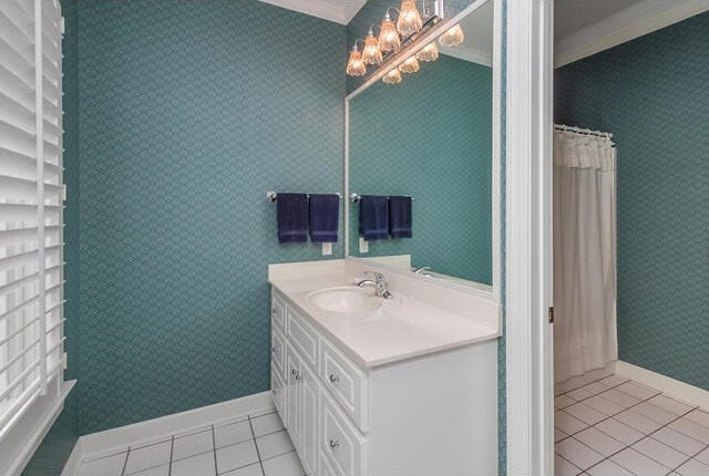 bathroom with tile patterned floors, an inviting chandelier, vanity, and ornamental molding