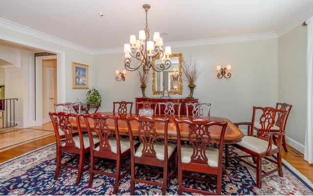 dining room with hardwood / wood-style floors, a notable chandelier, and ornamental molding