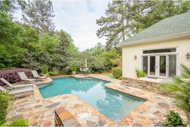 view of swimming pool with french doors and a patio area