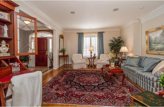 living room featuring wood-type flooring and ornamental molding