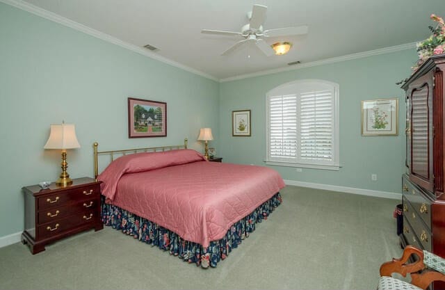 bedroom with light colored carpet, ceiling fan, and ornamental molding