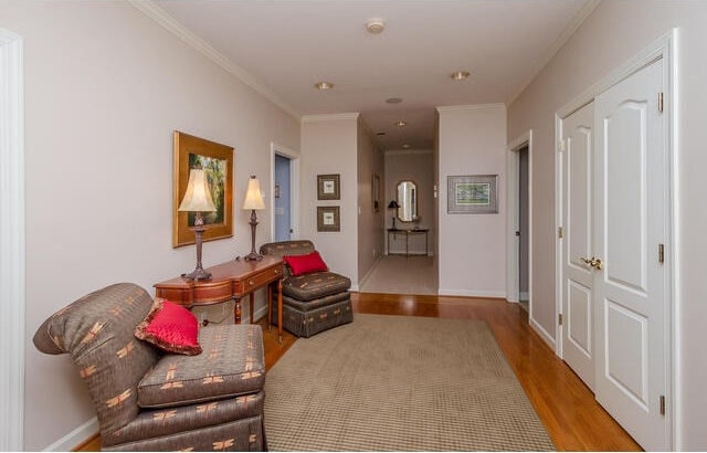 sitting room featuring light wood-type flooring and crown molding