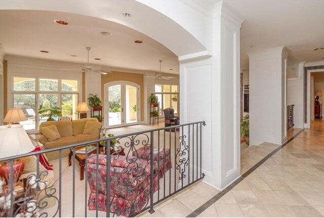 hallway with light tile patterned floors, french doors, and ornamental molding