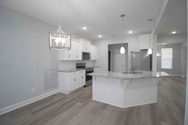 kitchen featuring appliances with stainless steel finishes, dark wood-style flooring, white cabinets, a kitchen breakfast bar, and recessed lighting