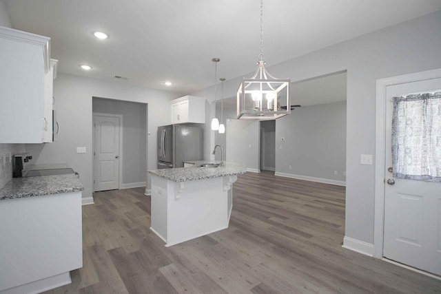 kitchen with freestanding refrigerator, a sink, white cabinetry, range, and a chandelier