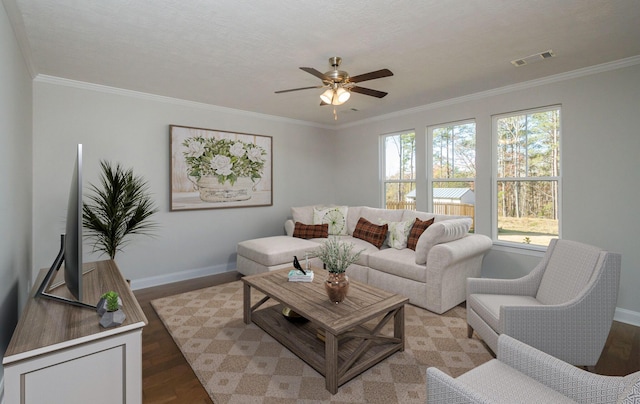 living room with hardwood / wood-style flooring, crown molding, and ceiling fan