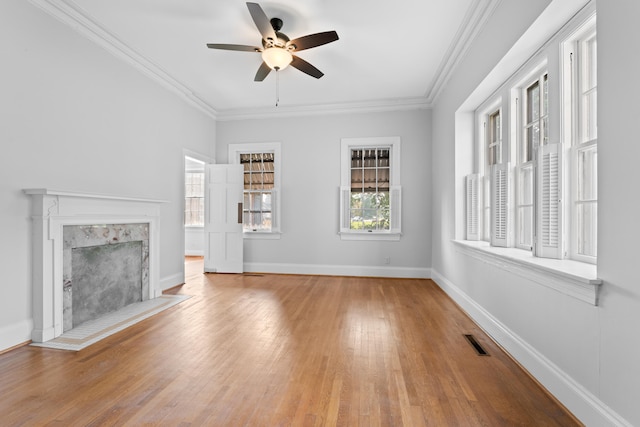 unfurnished living room featuring ceiling fan, light wood-type flooring, and ornamental molding