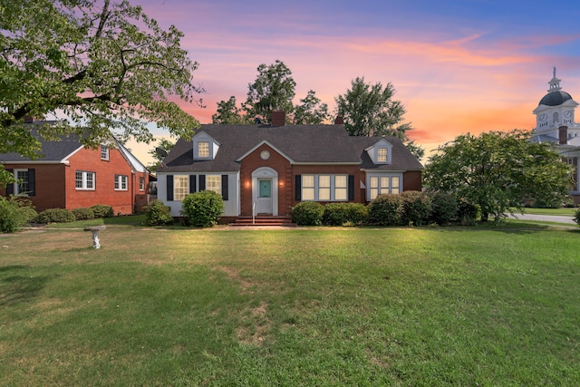 cape cod home with a lawn