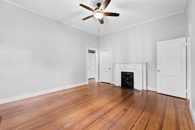 unfurnished living room featuring hardwood / wood-style floors, ceiling fan, ornamental molding, and a brick fireplace