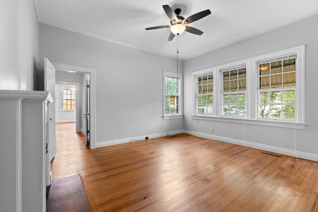 empty room featuring ceiling fan, wood-type flooring, and crown molding