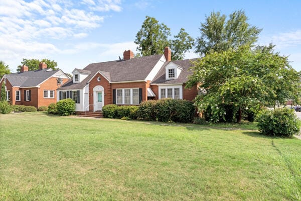 cape cod home with a front yard