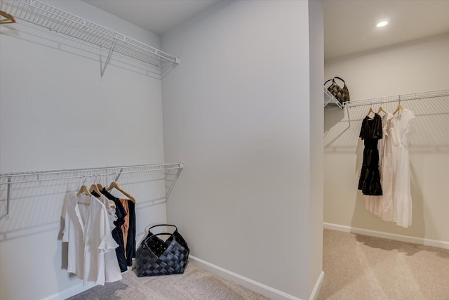 walk in closet featuring light carpet