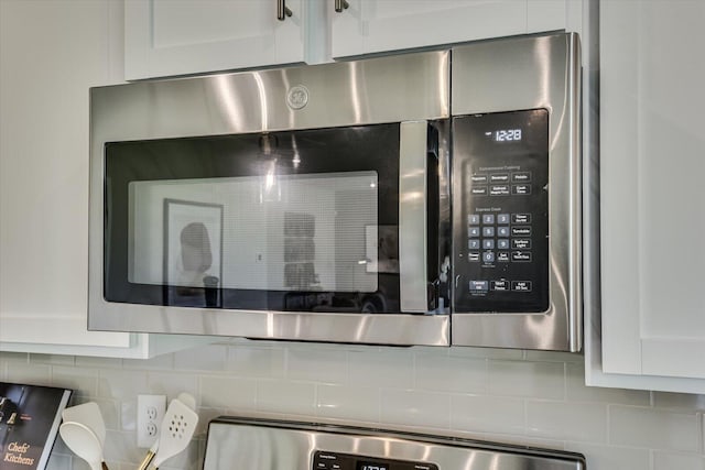 room details featuring white cabinetry and decorative backsplash