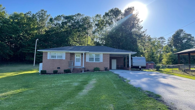 119 Eddie Dr, Mccormick, SC 29835 - ranch-style home with asphalt driveway, brick siding, an attached carport, and view of wooded area