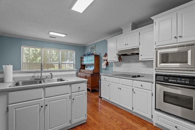 721 Spalding Ct, Martinez, GA 30907 - kitchen with appliances with stainless steel finishes, a sink, under cabinet range hood, white cabinets, and ornamental molding