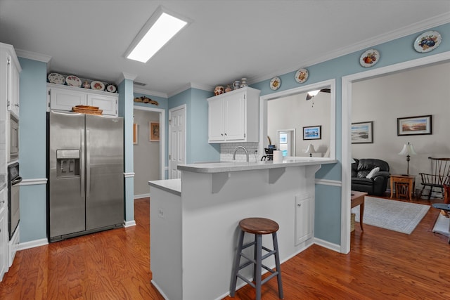 721 Spalding Ct, Martinez, GA 30907 - kitchen with appliances with stainless steel finishes, a breakfast bar area, light wood-type flooring, light countertops, and white cabinetry