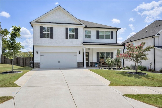 view of front of property with covered porch, a garage, and a front lawn