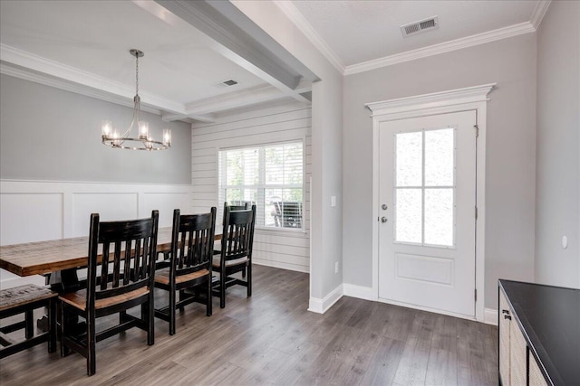 dining area with beam ceiling, coffered ceiling, dark hardwood / wood-style flooring, crown molding, and a chandelier