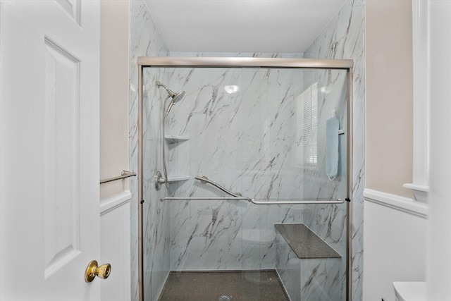 room details featuring toilet and a shower with shower door