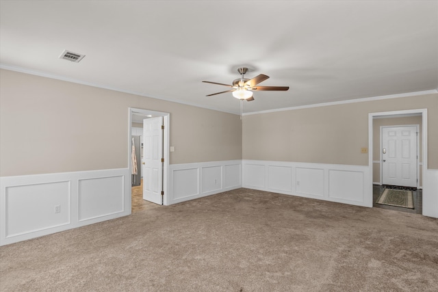 spare room featuring ceiling fan, ornamental molding, and light carpet