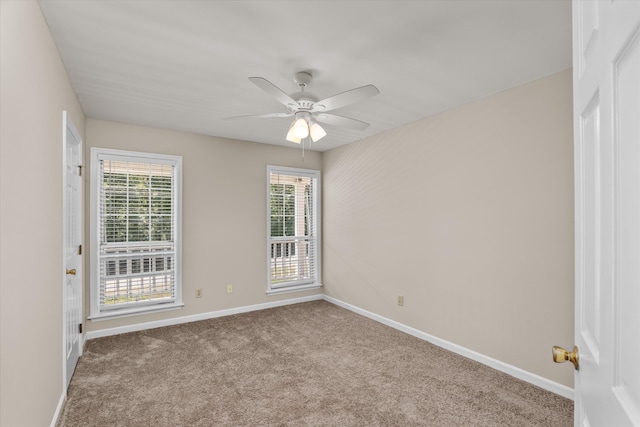 spare room with ceiling fan, light colored carpet, and a wealth of natural light