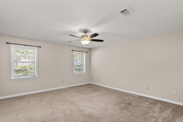 carpeted spare room with ceiling fan and a healthy amount of sunlight